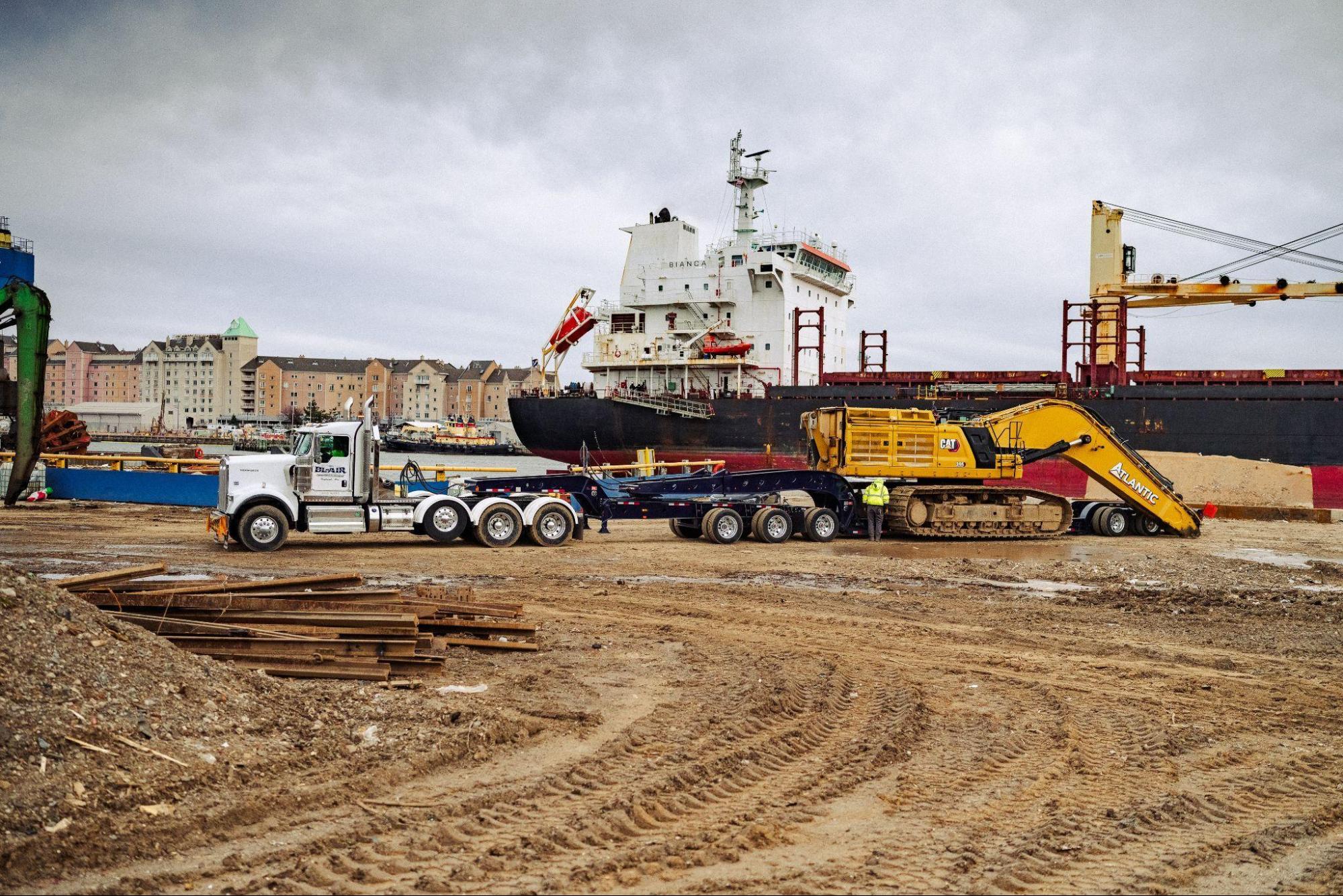 B. Blair heavy haul truck loading CAT excavator at port job site