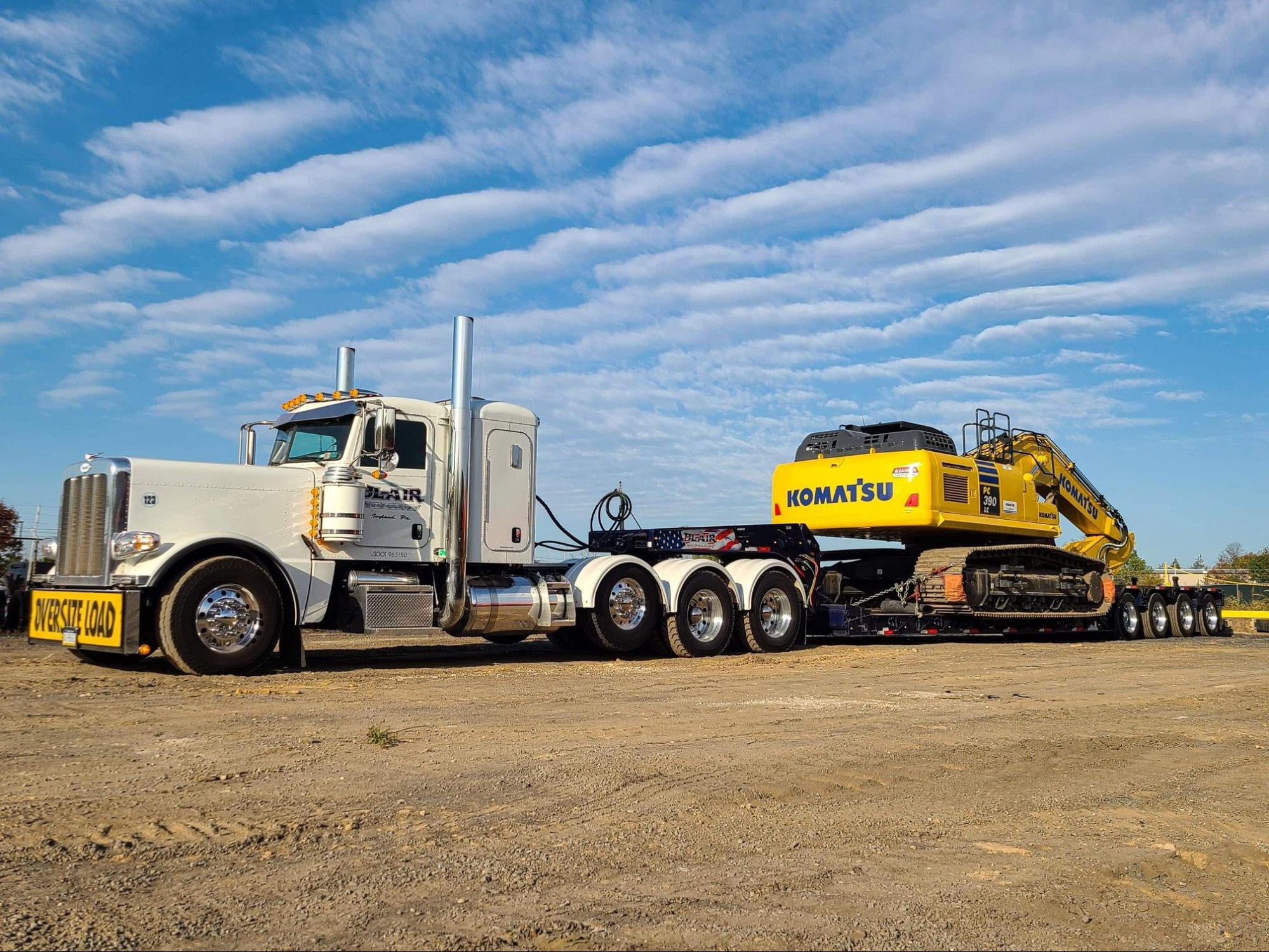 B. Blair Peterbilt heavy haul truck transporting Komatsu excavator on lowboy